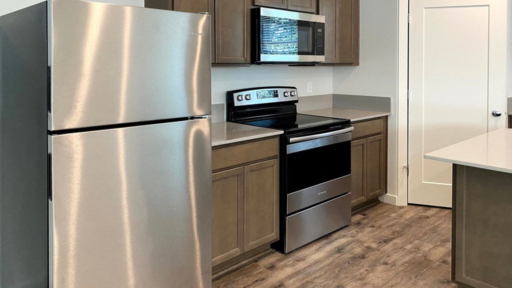A kitchen with a stainless steel refrigerator and a stainless steel oven.
