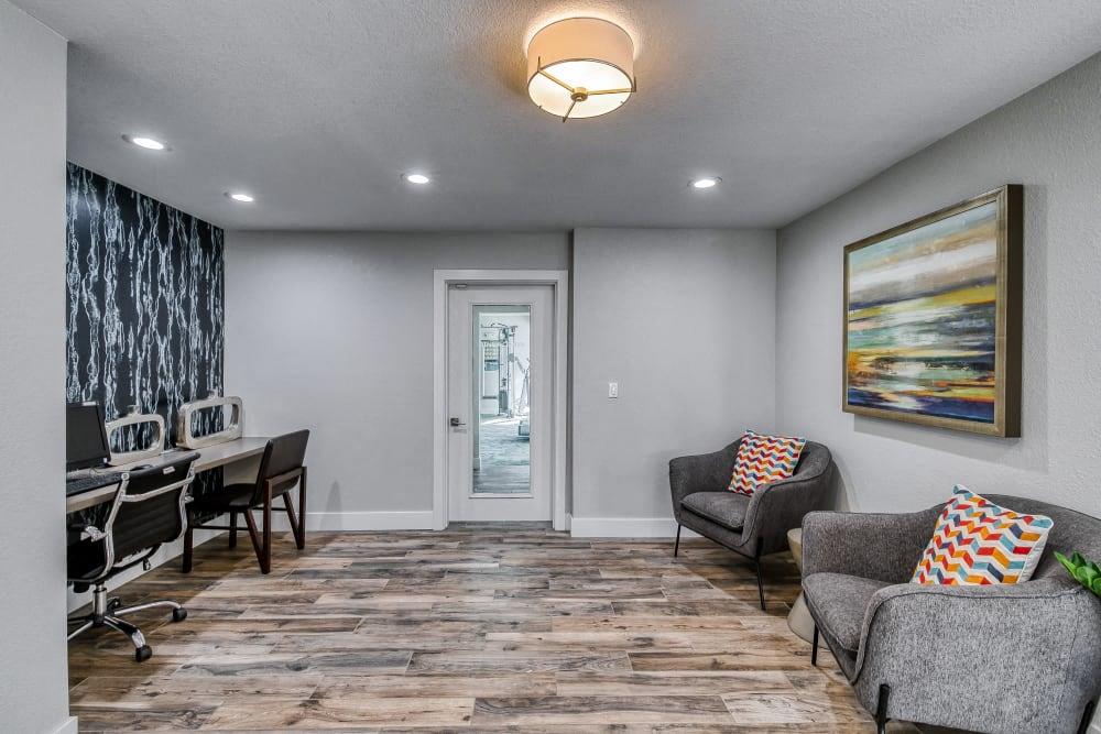 a living room with two chairs and a desk and a door