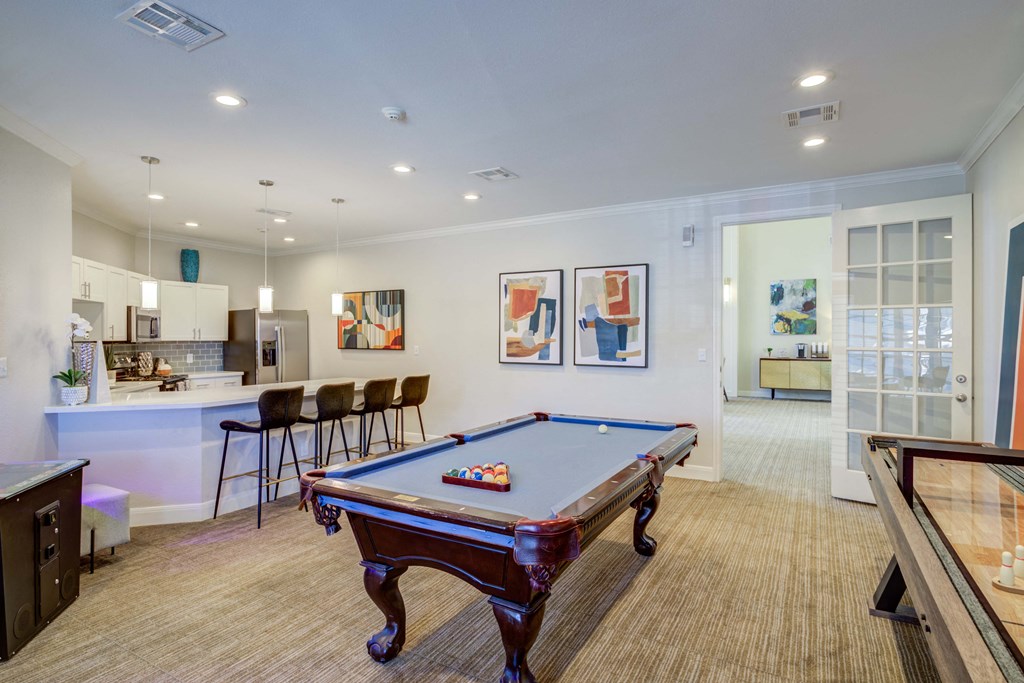a games room with a pool table and a bar