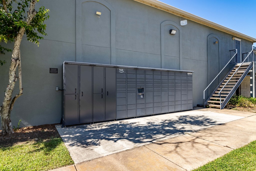 a gray building with a garage door and a staircase