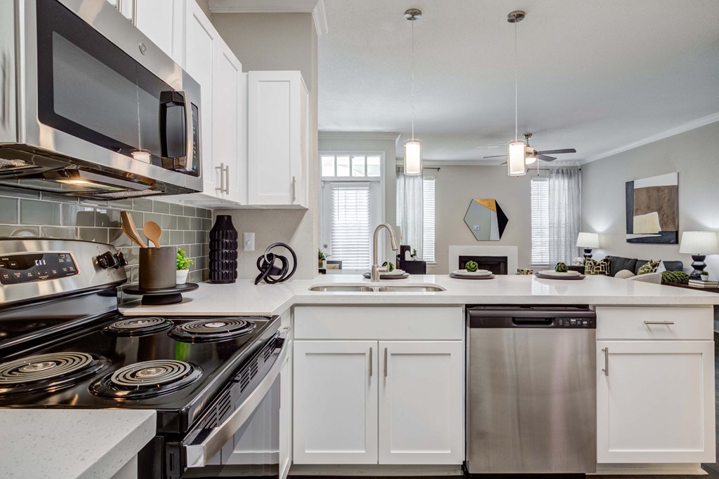 an open kitchen with white cabinets and stainless steel appliances