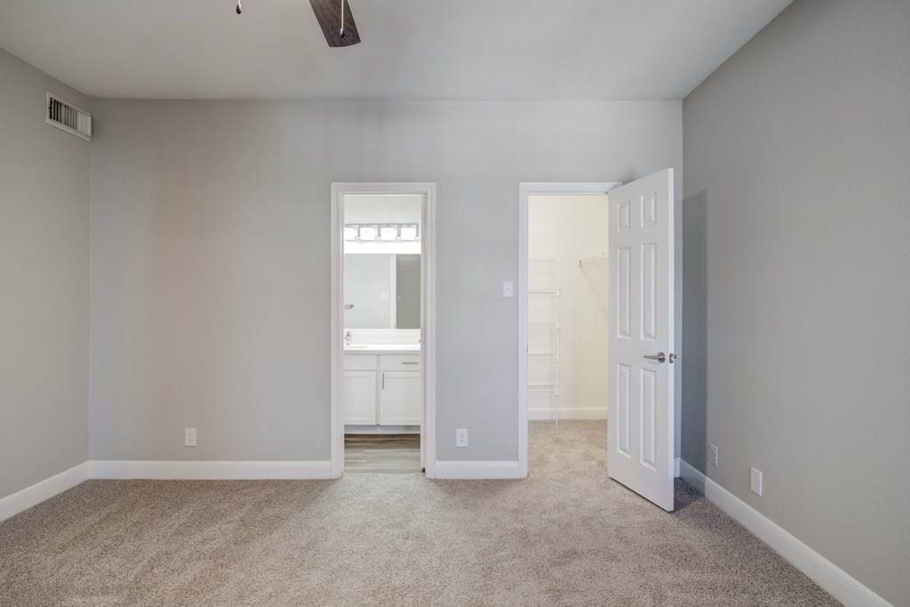 an empty living room with a door to a bathroom