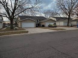 A residential street with houses and cars.