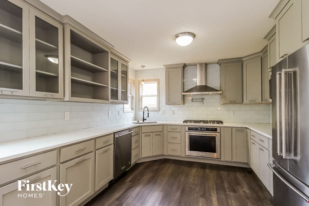 a kitchen with white cabinets and stainless steel appliances