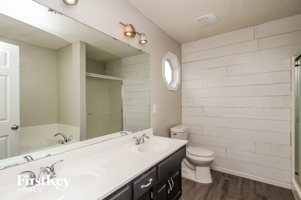 a bathroom with a large mirror and a sink and a toilet