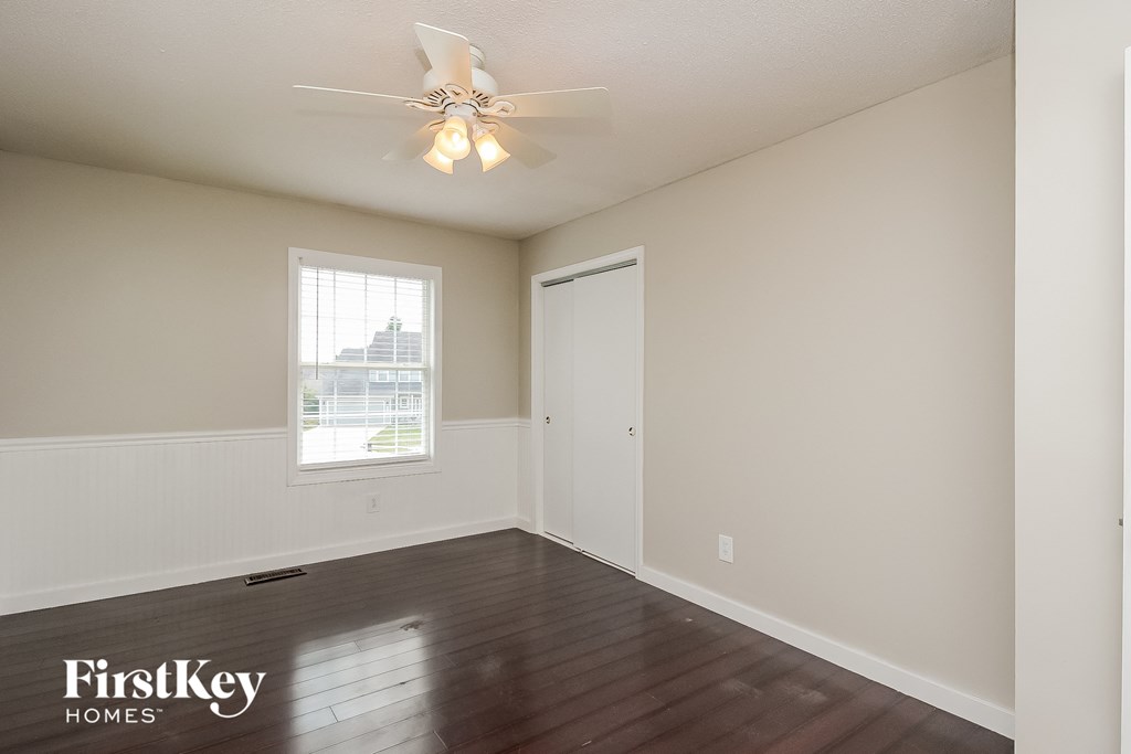 a empty living room with a ceiling fan and a window