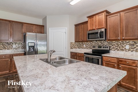 a kitchen with wooden cabinets and granite counter tops and a sink