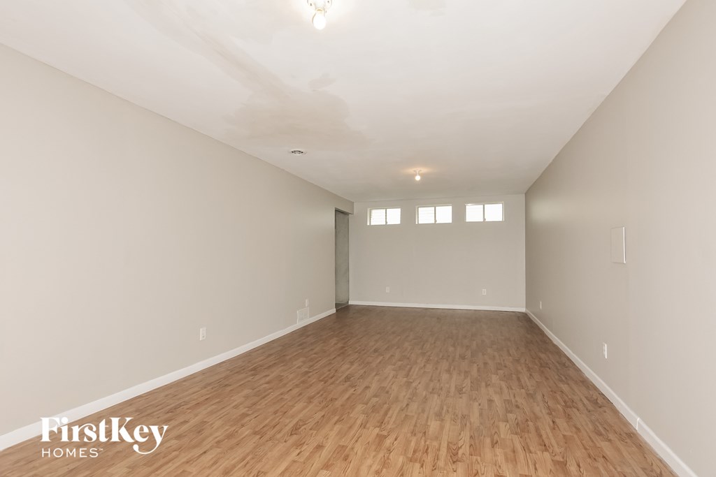 the living room with wood flooring and white walls