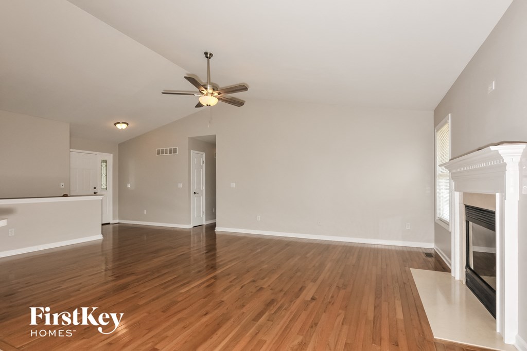 a living room with a fireplace and a ceiling fan