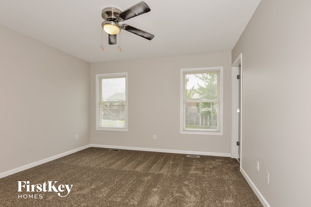 the living room of an empty house with a ceiling fan