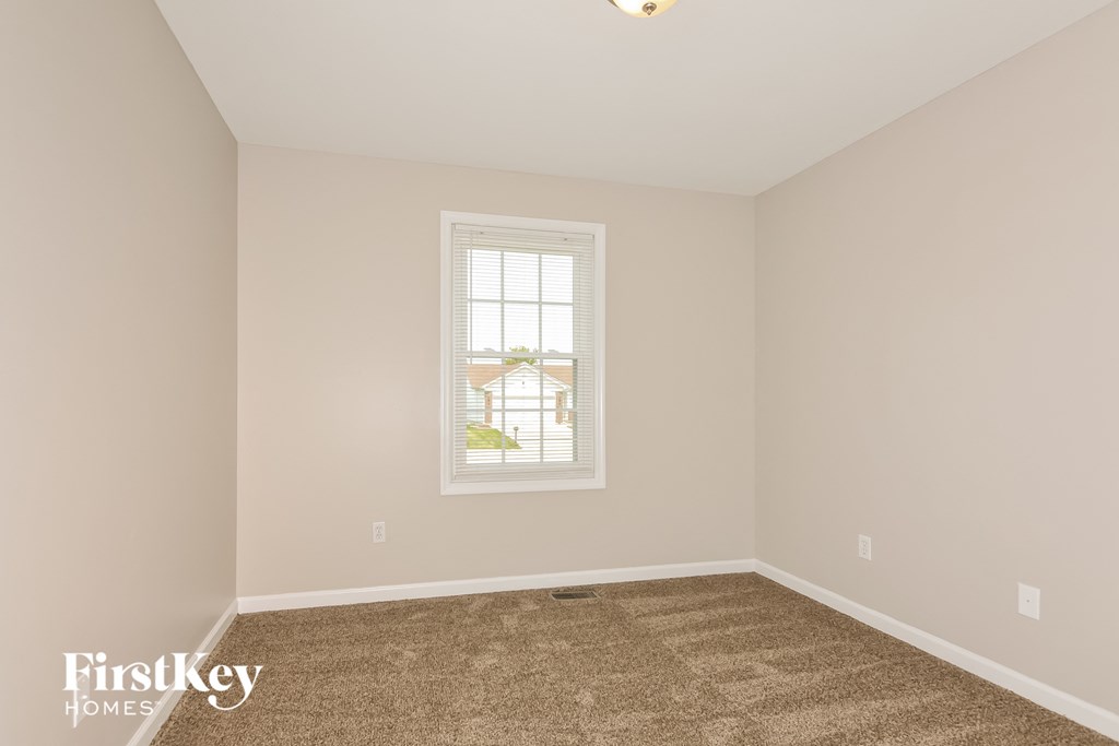 a bedroom with a carpeted floor and a window