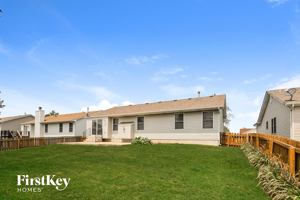 a white house with a yard and a wooden fence