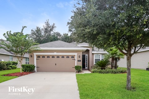 a home with a garage door and a lawn