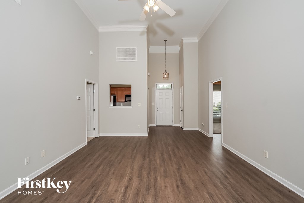 a spacious living room with white walls and wood flooring