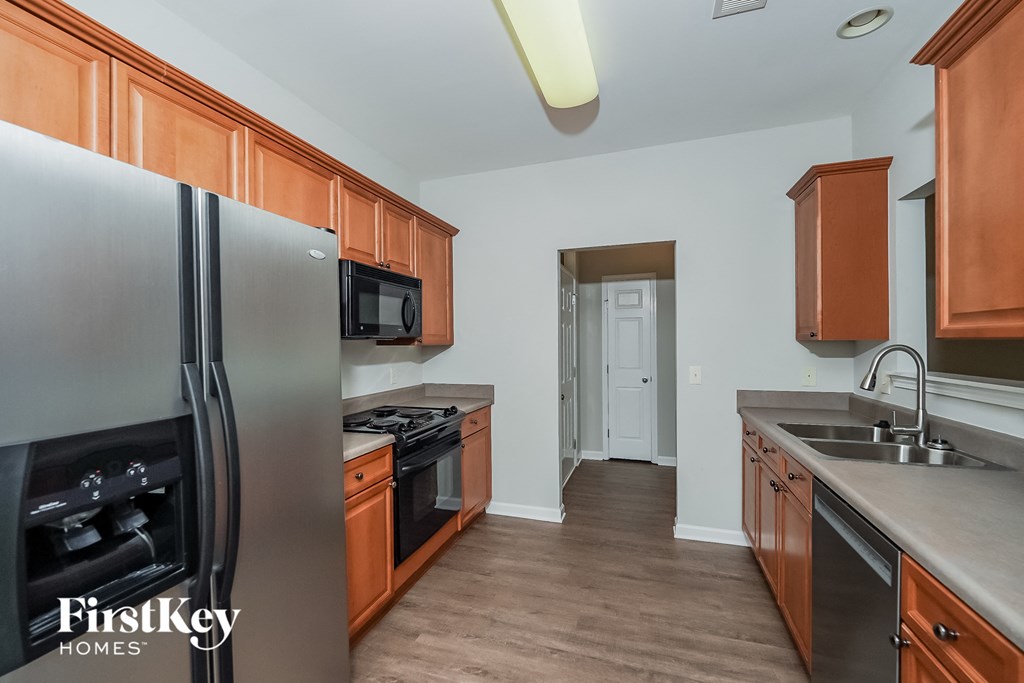 a kitchen with wooden cabinets and stainless steel appliances and a refrigerator