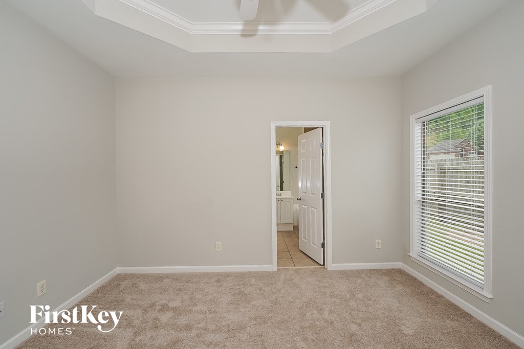 a bedroom with a carpeted floor and a large window