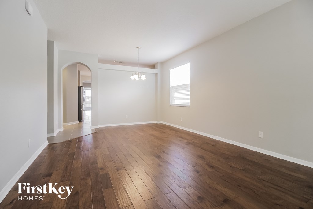 the living room and dining room with hardwood floors and white walls