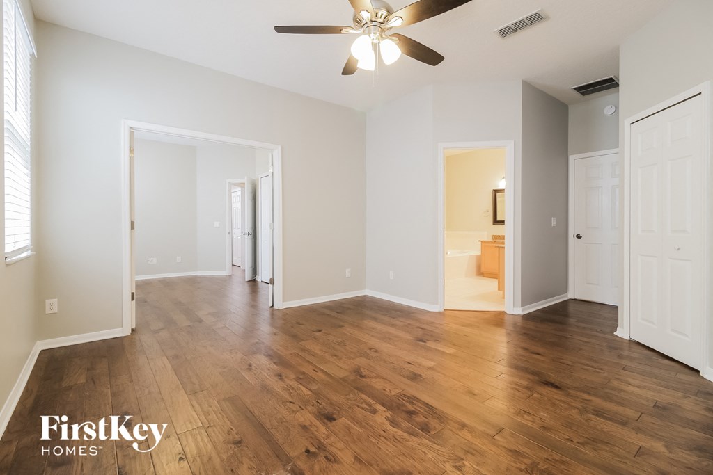 a living room with hardwood floors and a ceiling fan