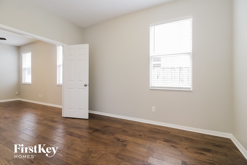 a living room with wood floors and a white door