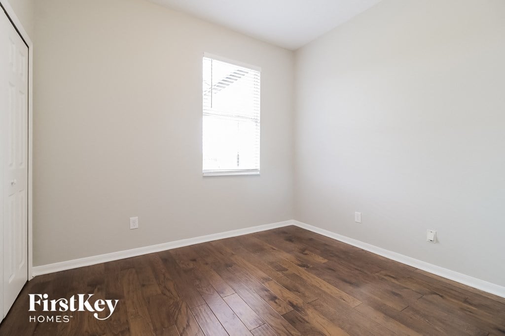 an empty room with wooden floors and a window