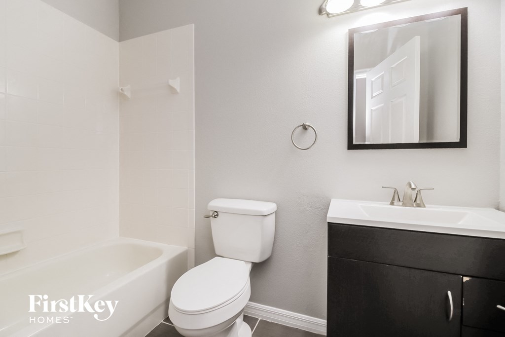 a bathroom with a toilet sink and tub and a mirror