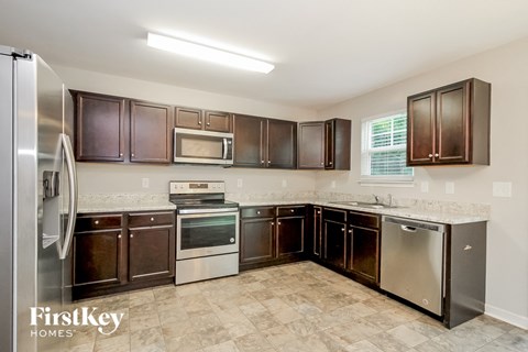 a kitchen with dark wood cabinets and stainless steel appliances
