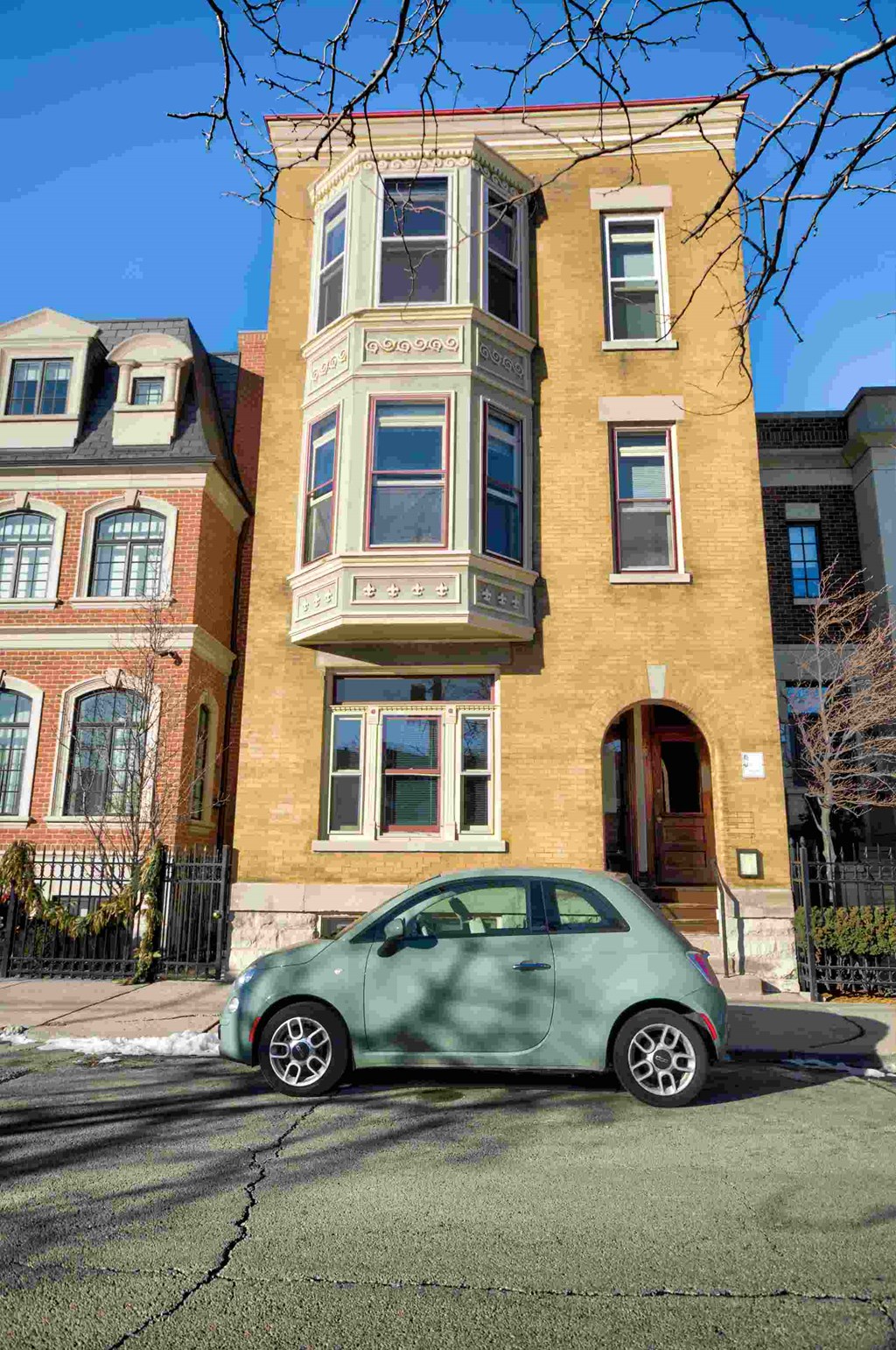 a green car parked in front of a building