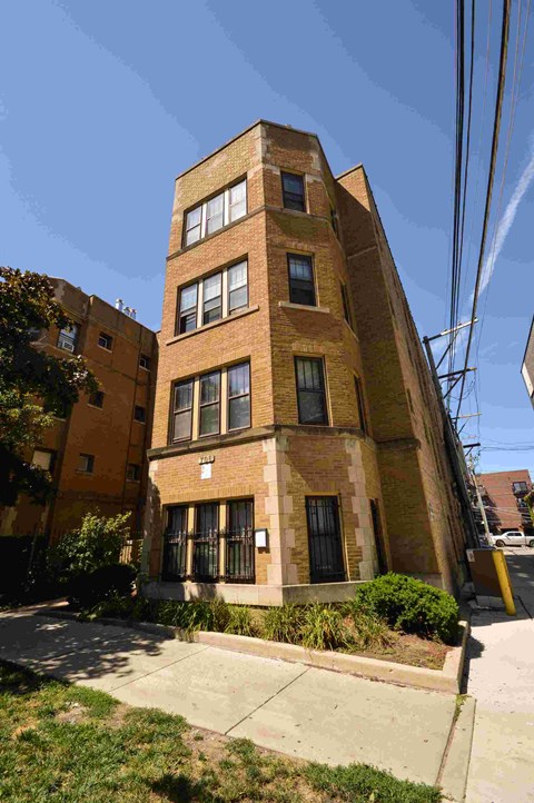 a tall brick building with a sidewalk in front of it