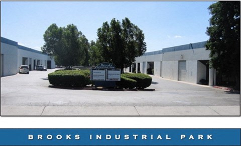 A sign in front of a building that says Brooks Industrial Park.