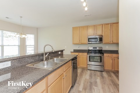 A kitchen with wooden cabinets and a stainless steel sink.
