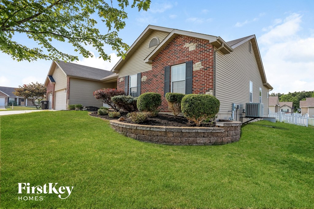 a home with a front yard with a retaining wall and landscaping