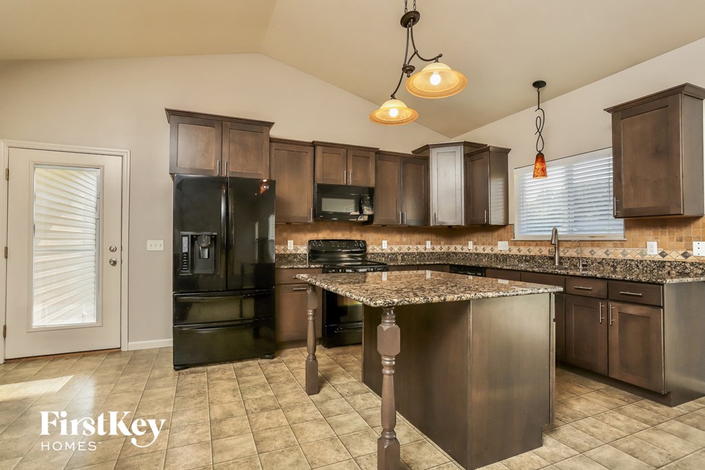 a kitchen with black appliances and granite counter tops