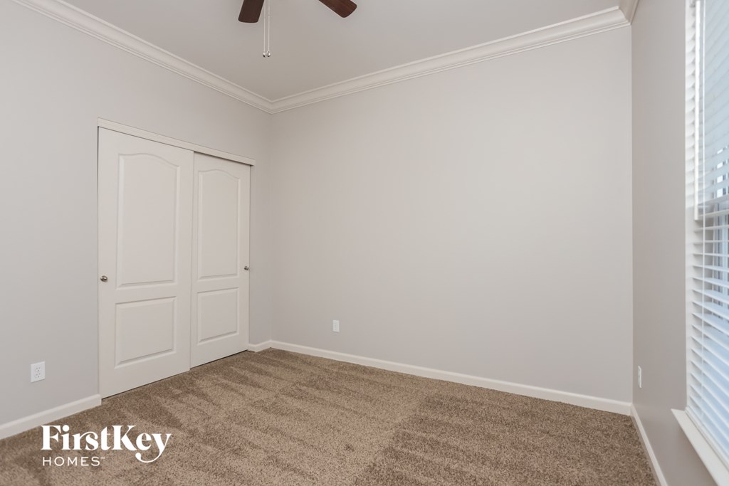 a bedroom with a carpeted floor and a closet