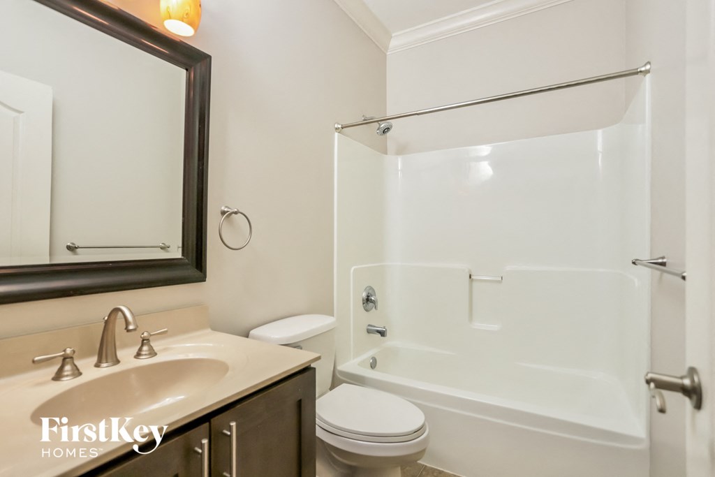 a bathroom with a shower toilet and sink and a mirror