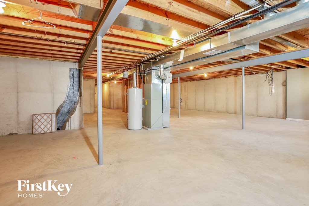 a large basement with exposed beams and a tree in the corner