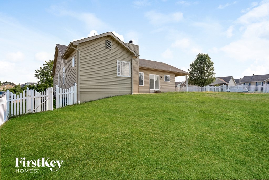 a house with a yard and a white fence