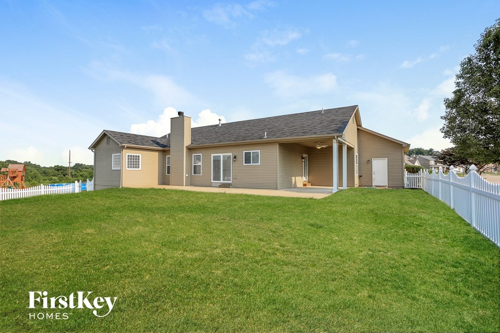 a house with a yard and a white fence