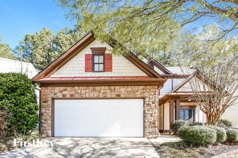 A house with a red window and a white garage door.