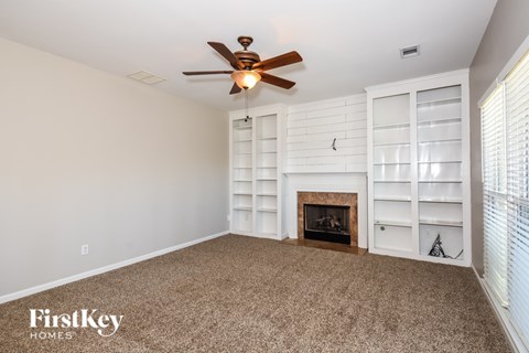 A room with a fireplace and a ceiling fan.