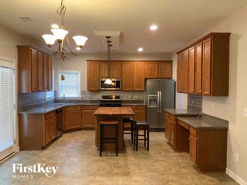 A kitchen with wooden cabinets and a black countertop.