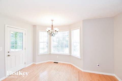 a dining room with a chandelier and three windows