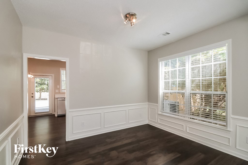 a living room with white walls and a large window