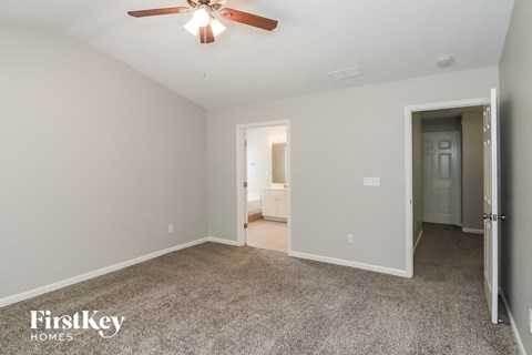 a living room with carpet and a ceiling fan