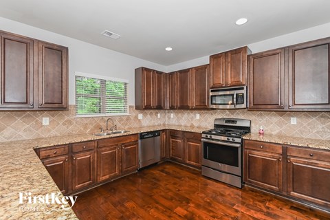 A kitchen with wooden cabinets and a stainless steel stove.