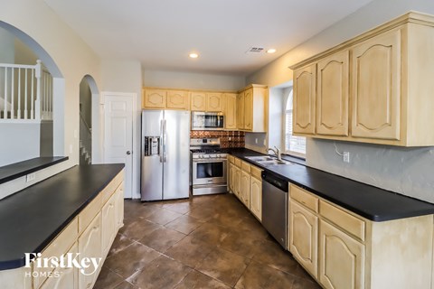 a large kitchen with wooden cabinets and stainless steel appliances