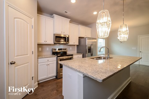 a kitchen with white cabinets and a marble counter top