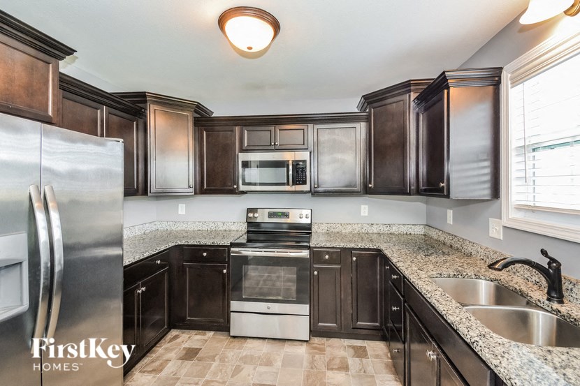 A kitchen with a stainless steel refrigerator and black cabinets.