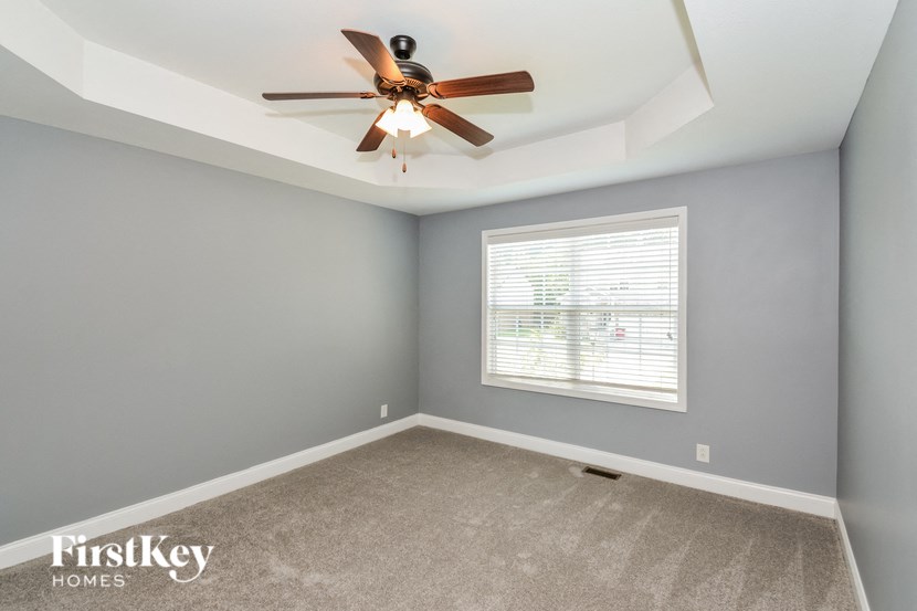 A room with a ceiling fan and a window.