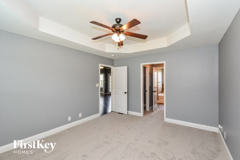 A room with a ceiling fan and two doors.