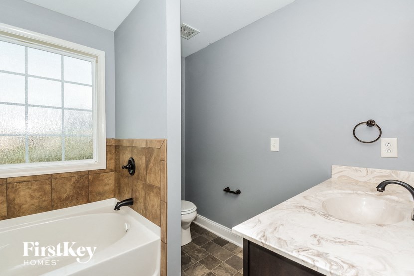 A bathroom with a tub, toilet, and sink.